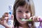 Child measures time while brushes her teeth. Healthy habits, dentalcare concept. Close up