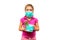 A child in a medical mask holds a flower pot in his hands. Girl with a houseplant isolated on a white background. The concept of