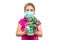 A child in a medical mask holds a flower pot in his hands. Girl with a houseplant isolated on a white background. The concept of a