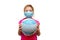 A child in a medical mask holds a globe wrapped in bandages in his hands. Little girl heals the planet. The concept of air polluti