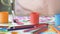 Child mixing drawing colors with brush, close-up of gouache paint cans, art