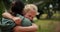 Child, mother and hug at a park outdoor in nature for happiness, adventure or fun play. A woman and girl kid embrace in