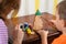 The child and Mother paints a wooden New Year`s Christmas tree. Little boy and mother draws a new-year tree