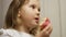 Child mouth bites rose donut. Closeup baby girl eating doughnut with glase. Delicious, sweet, sweettooth