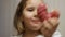 Child mouth bites rose donut. Closeup baby girl eating doughnut with glase. Delicious, sweet, sweettooth.