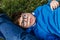 Child with multiple disabilities enjoying the outdoors while laying on the grass in the park.