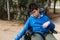 Child with multiple disabilities in a wheelchair enjoying the day outdoors in the park.