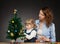 Child with mummy decorates the Christmas tree