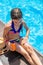 Child near the pool smears sunscreen. Selection focus.