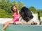 Child and newfoundland dog in swimming pool