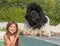 Child and newfoundland dog in swimming pool