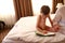 Child with notepad on bed in hotel