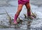 Child outdoor jump into puddle in boot after rain