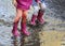 Child outdoor jump into puddle in boot after rain