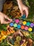 Child paints pine cones for kids