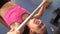 Child performs a bench press lying with a trainer. girl strengthens the muscles of hands. Fitness club teenager goes in