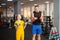 child performs an exercise with dumbbells with a trainer