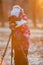 Child photographer taking pictures on camera using tripod, sunset light