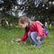 Child picking daisy flowers