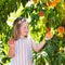 Child picking and eating peach from fruit tree