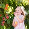 Child picking and eating peach from fruit tree