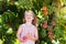 Child picking and eating peach from fruit tree