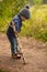 The child is picking the ground with a stick