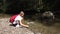 Child Picking River Pebbles in Mountains Waterfall, Kid Playing in River Water, Girl Throwing Stones in Spring, Hiking at Camping