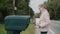 A child picks up letters from a street mailbox in a US suburb. Side view