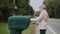 A child picks up letters from a street mailbox in a US suburb. Side view