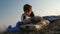 A child at a picnic reading a book in the sunset