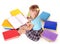 Child with pile of books reading on floor.