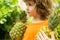 Child with pineapple in garden. Kids in tropical resort. Family summer vacation on exotic island. Fruit for children.
