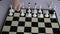 a child places a white chess set on a chessboard for playing