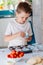 Child placing cupcake forms in baking tray