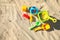 Child plastic toys on sandy beach, flat lay. Space for text