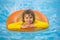Child play in pool on inflatable ring. Kid with inflatable ring in swimming pool. Child water toys. Children play in