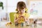 Child playing with animal toys at table in kindergarten or home