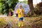 Child playing in autumn rain. Kid with umbrella