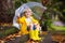 Child playing in autumn rain. Kid with umbrella