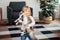 Child playing with baby cat. Kid holding black kitten. Little girl snuggling cute pet animal in sunny living room at home. Kids