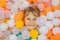 Child playing in ball pit. Colorful toys for kids. Kindergarten or preschool play room. Toddler kid at day care indoor