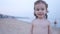 Child Playing on the Beach while Father Show how Sand Pours from Hands