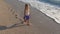 Child Playing on Beach at Sunset, Happy Kid Walking in Sea Waves Girl on Seaside