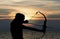 Child playing bow and arrow on the beach, Silhouette