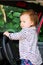 Child playing in car steering wheel. Cute little girl driving car. Child standing in big car.