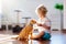 Child playing with cat at home. Kids and pets