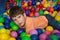 Child playing with colorful balls in playground ball pool. Activity toys for little kid. Kids happiness emotion having fun in ball