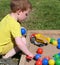 Child playing Colourful balls and buckets in childs sand pit