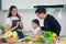 Child playing cook food with father and mother at home kitchen. Asian family happiness moment together